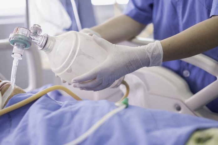 Doctor holding oxygen ambu bag over patient given oxygen to patient by intubation tube in ICU/Emergency room